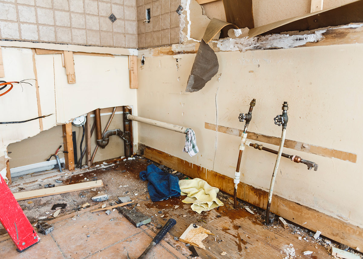 Severe water damage in a home — broken walls and flooded floor requiring emergency restoration