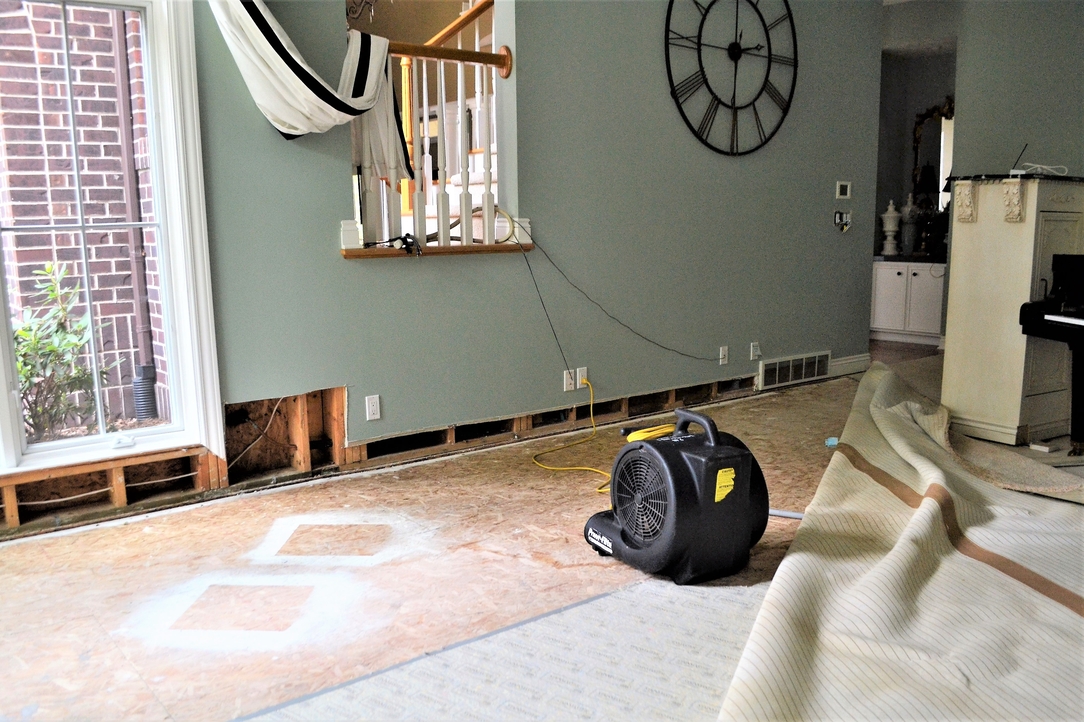 Home undergoing structural drying after flood damage — industrial fans and drying equipment in place